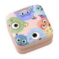 Boîte à bijoux rose nomade avec motif coloré de monstres aux grands yeux et formes rondes.