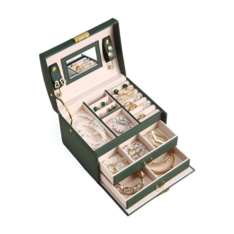 Boîte à bijoux nomade verte, multiples tiroirs ouverts, intérieur beige avec bijoux variés et miroir intégré.