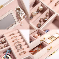 Boîte à bijoux rose poudré avec miroir intégré, tiroirs multiples et compartiments organisés pour bagues et boucles.