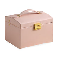 Boîte à bijoux nomade rose poudré en cuir avec poignée et fermeture dorée élégante.