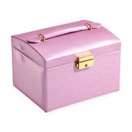 Boîte à bijoux rose poudré avec poignée, fermoir doré et design rectangulaire compact.