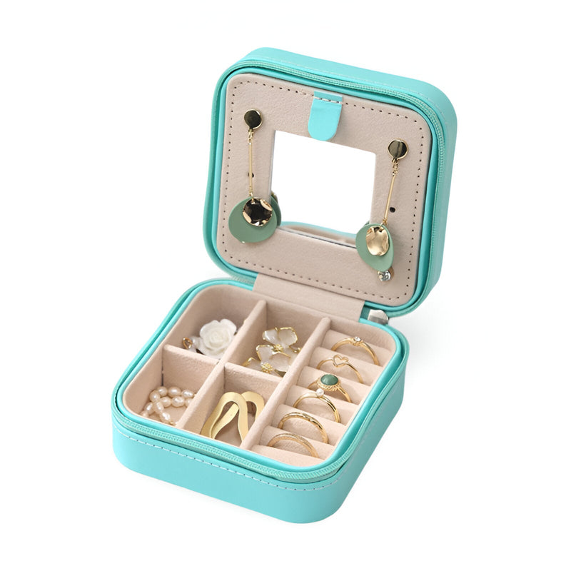 Boîte à bijoux nomade turquoise avec miroir intégré et compartiments pour bagues et boucles d'oreilles.
