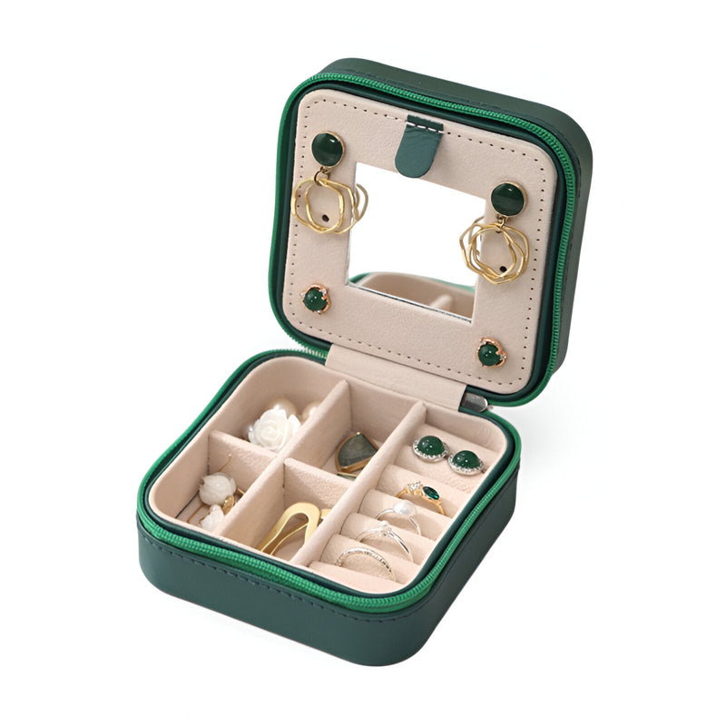 Boîte à bijoux nomade verte avec miroir intégré et compartiments organisateurs en velours beige.