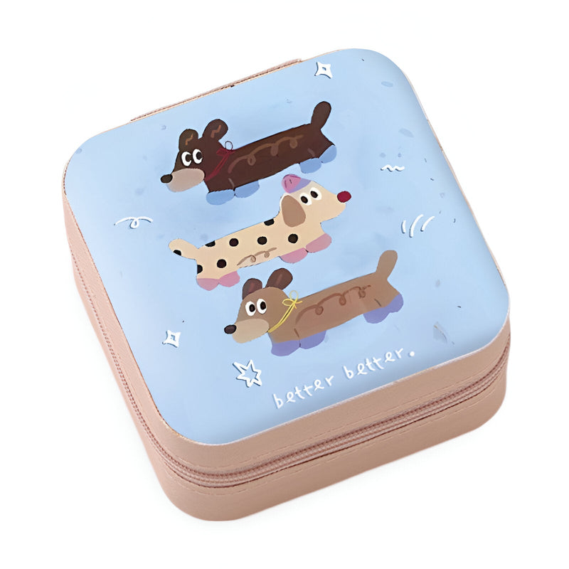Boîte à bijoux nomade bleue avec illustration enfantine de trois chiens allongés.