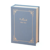 Boîte à bijoux nomade bleu style livre avec ornements dorés délicats et titre "Magic Book" sur la couverture.