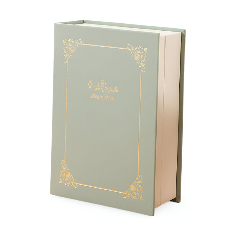 Boîte à bijoux nomade vert clair style livre avec ornements dorés élégants.