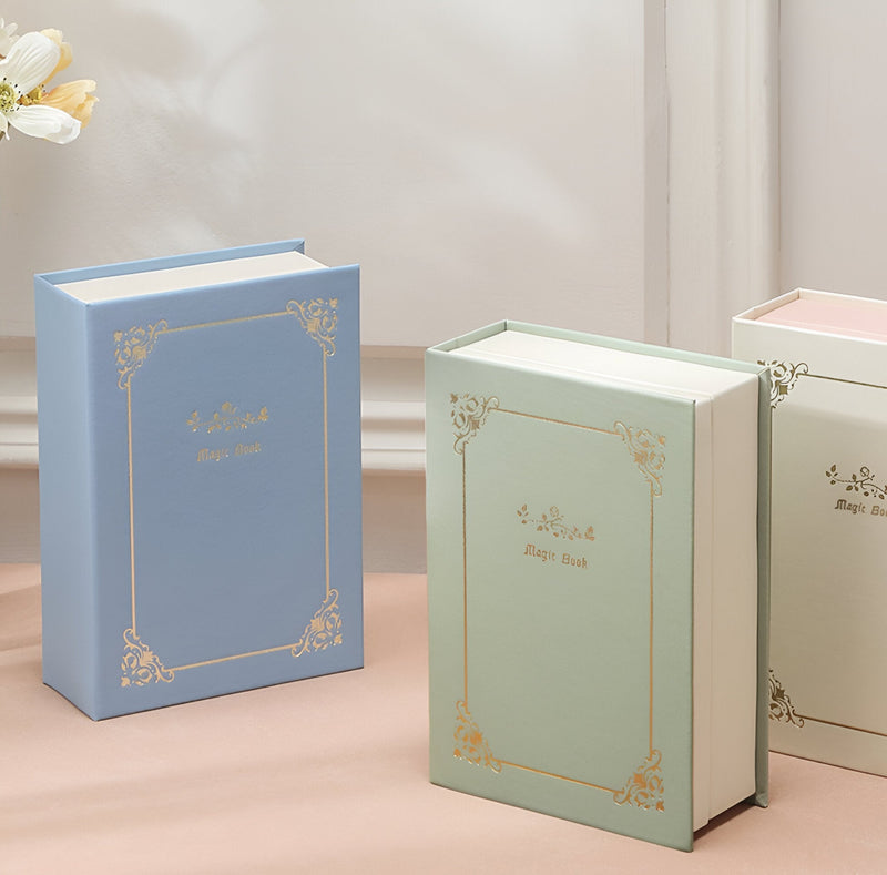 Boîte à bijoux nomade bleue aspect livre avec motifs dorés élégants.