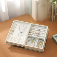 Boîte à bijoux nomade verte style livre magique avec compartiments et rangement pour bagues, colliers, boucles d’oreilles.