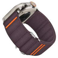 Bracelet nylon mauve foncé avec boucle ajustable et détails orange pour Apple Watch.