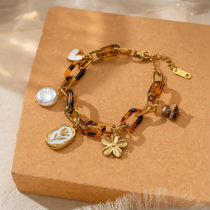 Bracelet à charms doré, maillons acrylique effet écaille, perle baroque, médaillon tulipe émail blanc, fleur dorée, acier inoxydable, ajustable, modèle Cladia