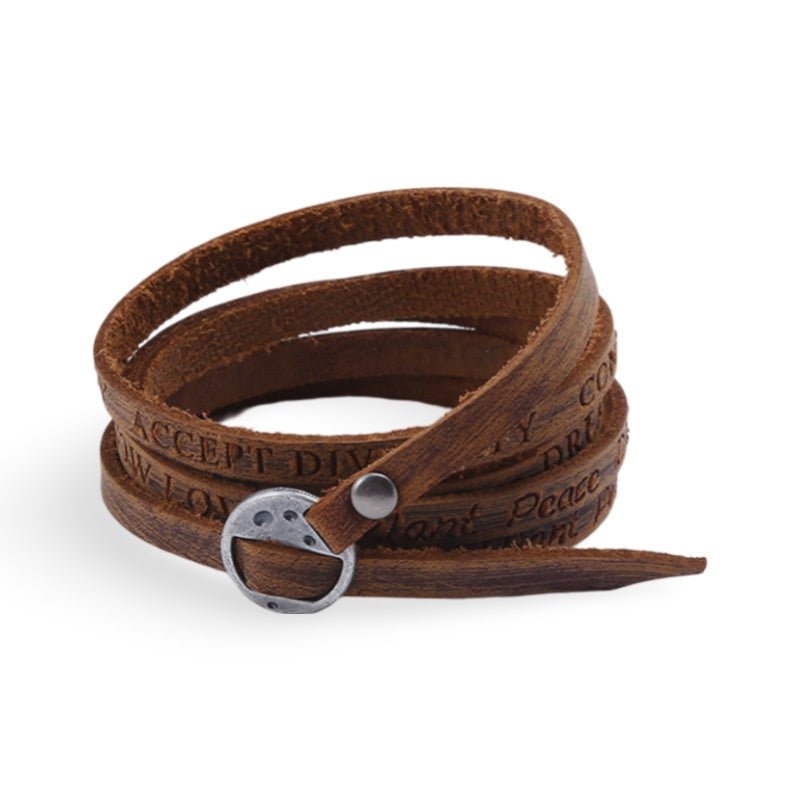 Bracelet à enrouler en cuir marron vintage avec boucle métallique argentée et gravure décorative.