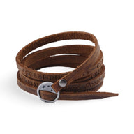 Bracelet à enrouler en cuir marron vintage avec boucle métallique argentée et gravure décorative.