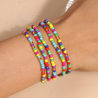 Bracelet à enrouler multicolore en perles de résine élastiques, porté au poignet féminin.