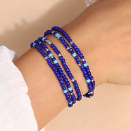 Bracelet à enrouler en perles de résine élastique bleu azur et bleu clair porté au poignet femme.