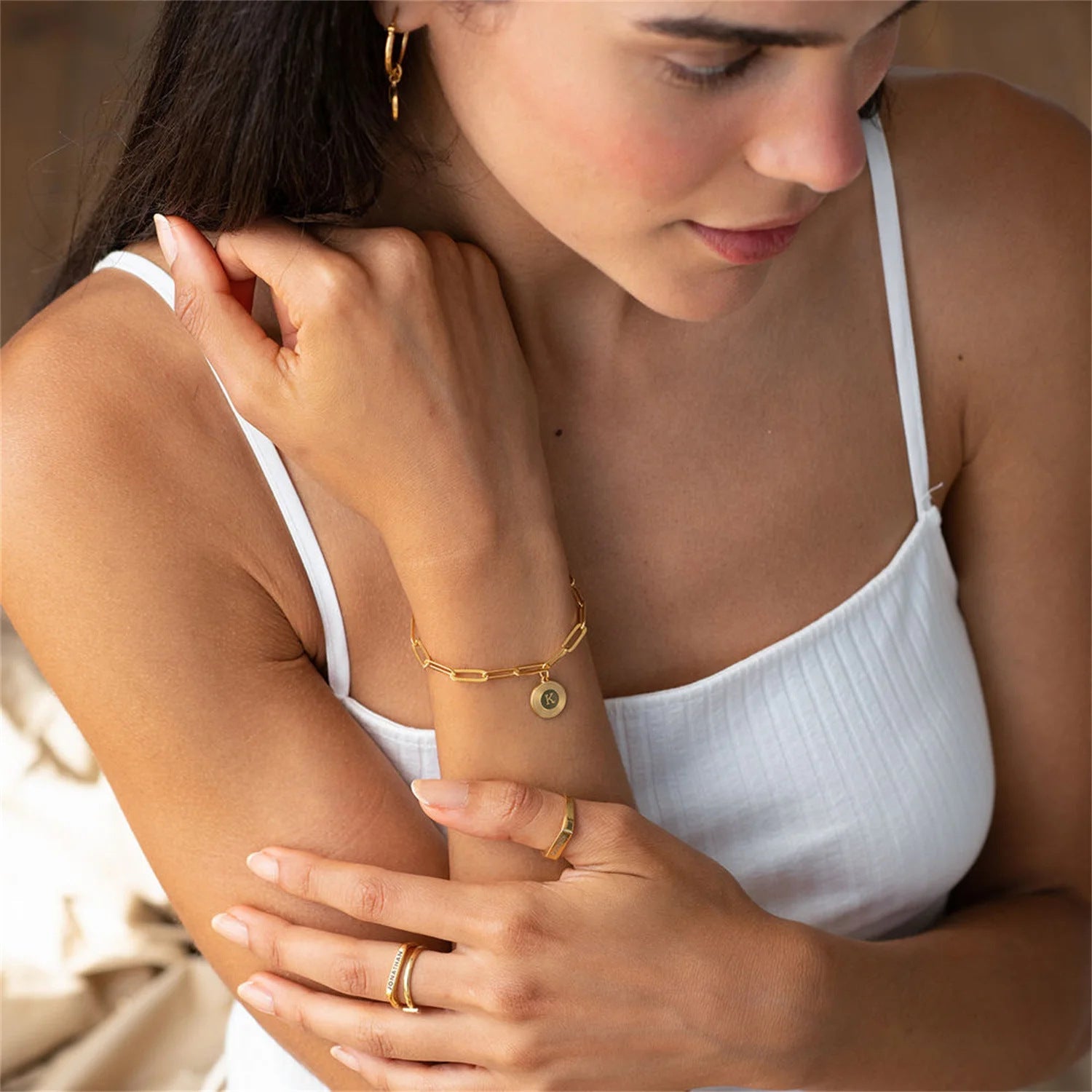 Armband mit rechteckigen Gliedern aus vergoldetem Edelstahl, personalisierbarer Anhänger in Medaillenform mit Buchstabe, elegante Kettenglieder im Büroklammer-Stil, Modell Calvina