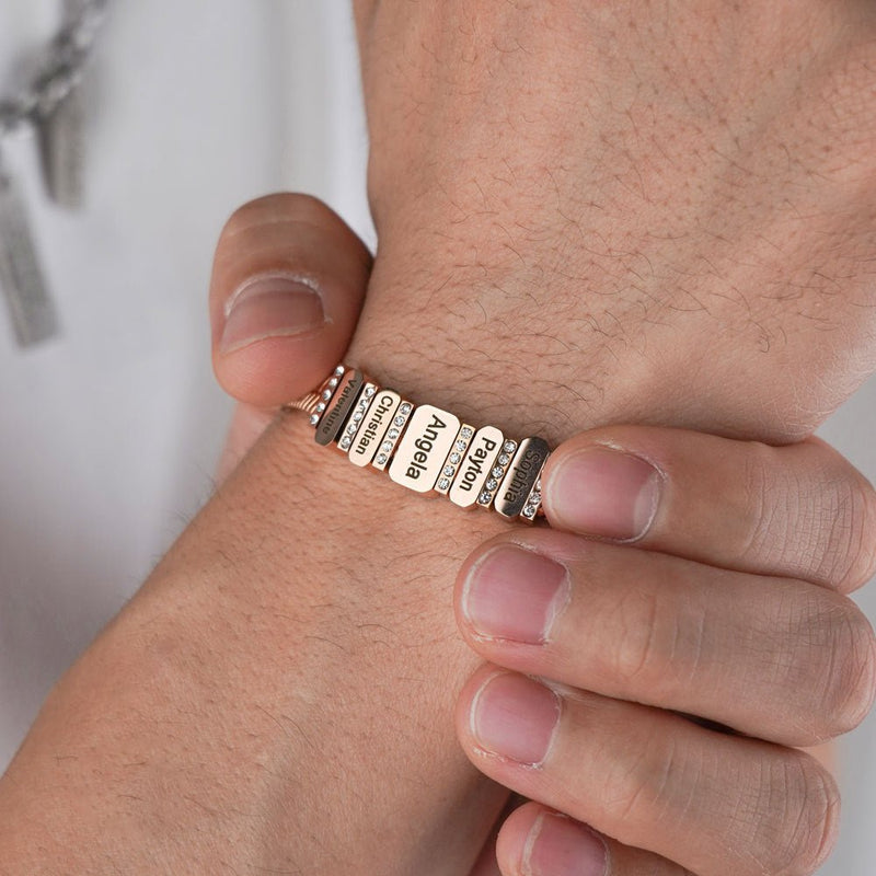 Bracelet à mailles serpent en acier inoxydable doré avec plaques gravées et zircons brillants, porté au poignet.