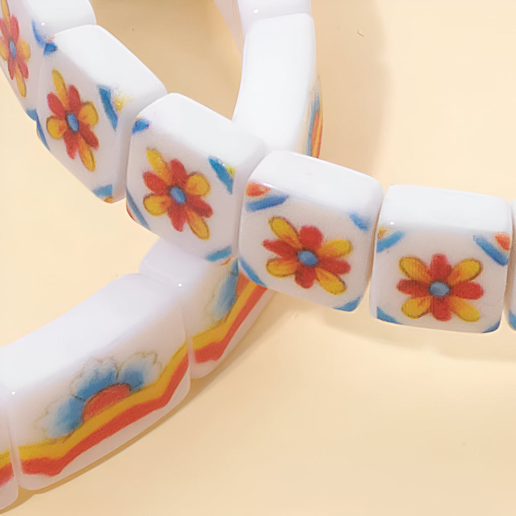 Bracelet en acrylique blanc avec motifs floraux colorés rouges, jaunes et bleus, style Hyacinth.