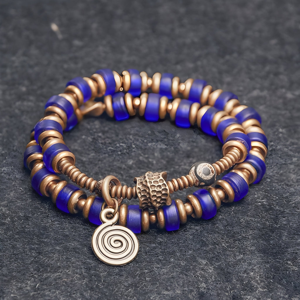 Bracelet à perles bleu en verre et anneaux en cuivre avec pendentif spirale pour femme.