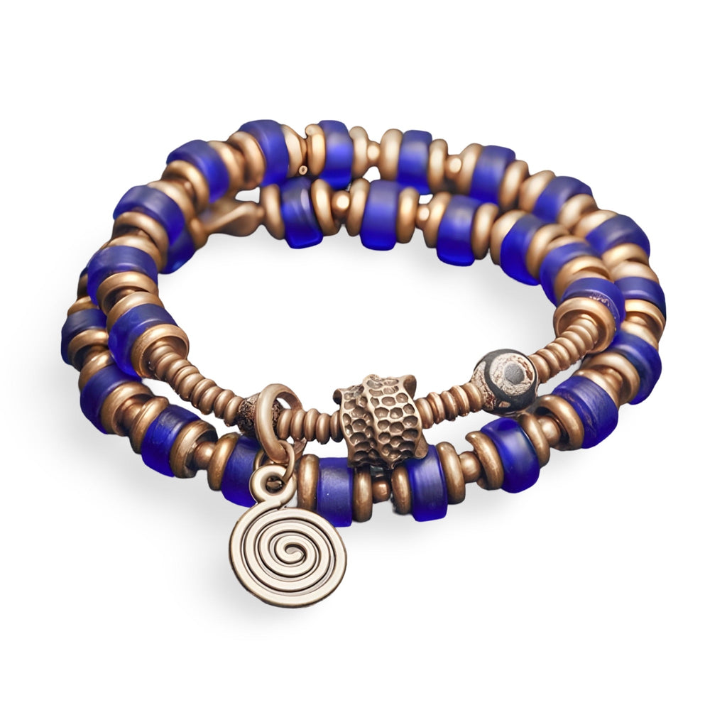 Bracelet à perles bleues en verre et éléments en cuivre avec pendentif spirale et fermoir décoratif.