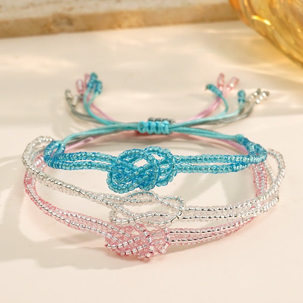 Bracelet ajustable en perles miyuki bleues et roses avec nœud central symbolique et cordon coulissant léger.