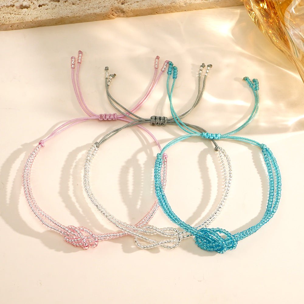 Trois bracelets réglables en perles miyuki colorées avec nœud central, cordon coulissant en rose, gris et bleu clair.