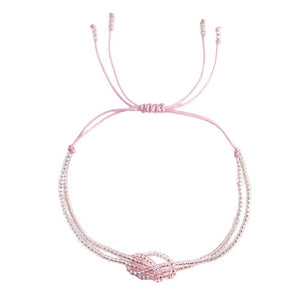 Bracelet rose clair à perles miyuki multicolores avec nœud central en perles, cordon coulissant ajustable.