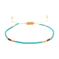 Bracelet fin en perles Miyuki turquoise, or et brun, cordon ajustable noué, style bohème chic.