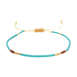 Bracelet fin en perles Miyuki turquoise, or et brun, cordon ajustable noué, style bohème chic.