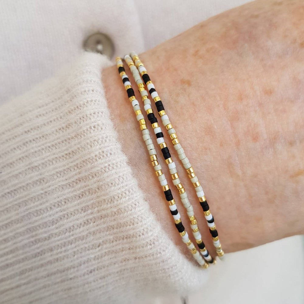 Bracelet à perles miyuki du japon fines multirangs, noir blanc doré, fermoir coulissant discret, modèle Grina