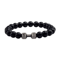 Bracelet à perles noires mat avec barre d'haltère argentée centrale, style musculation.