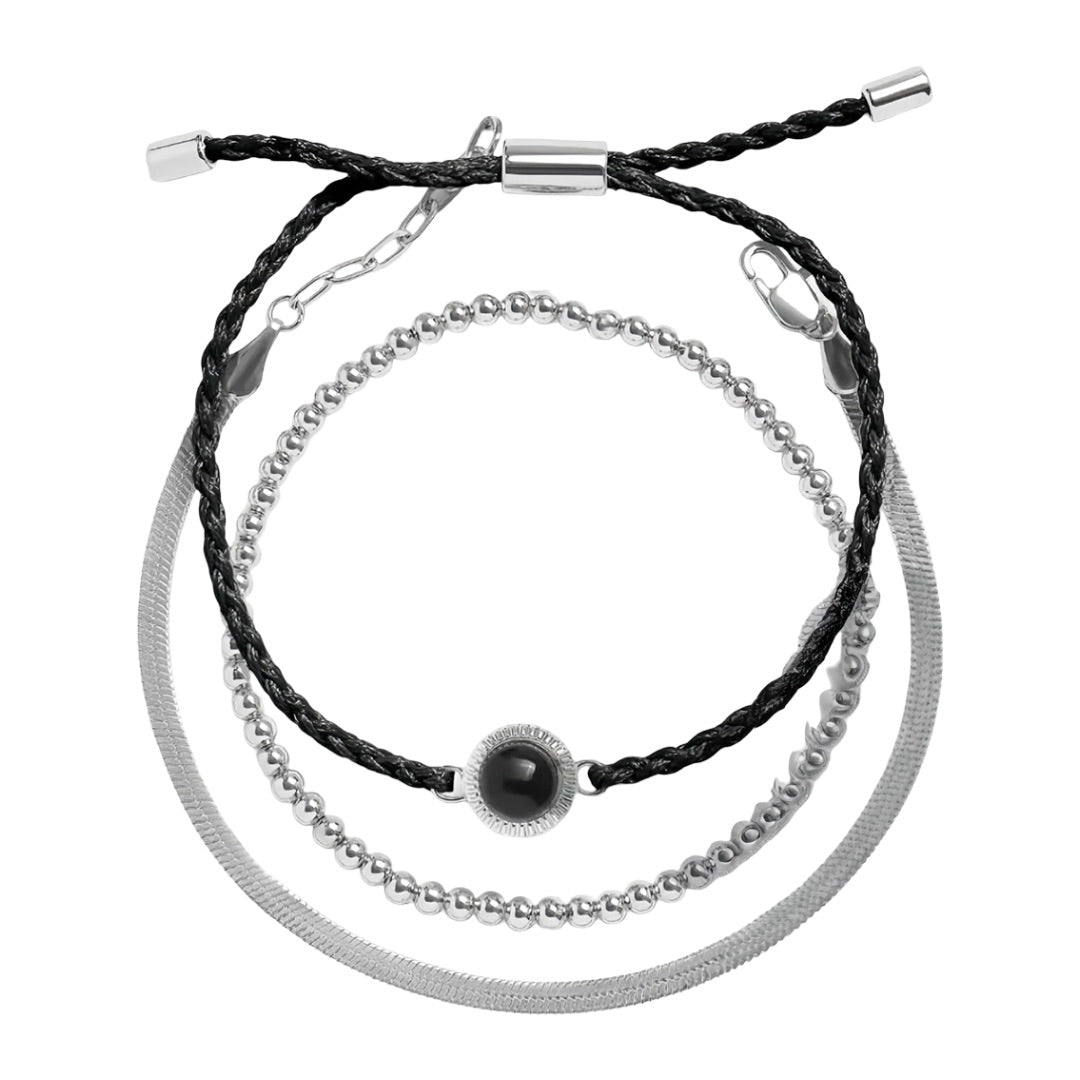 Bracelet trio avec perles dorées, cordon noir tressé et chaîne en acier inoxydable argenté.
