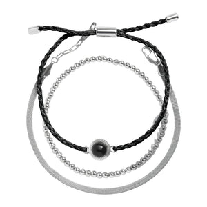 Bracelet trio avec perles dorées, cordon noir tressé et chaîne en acier inoxydable argenté.