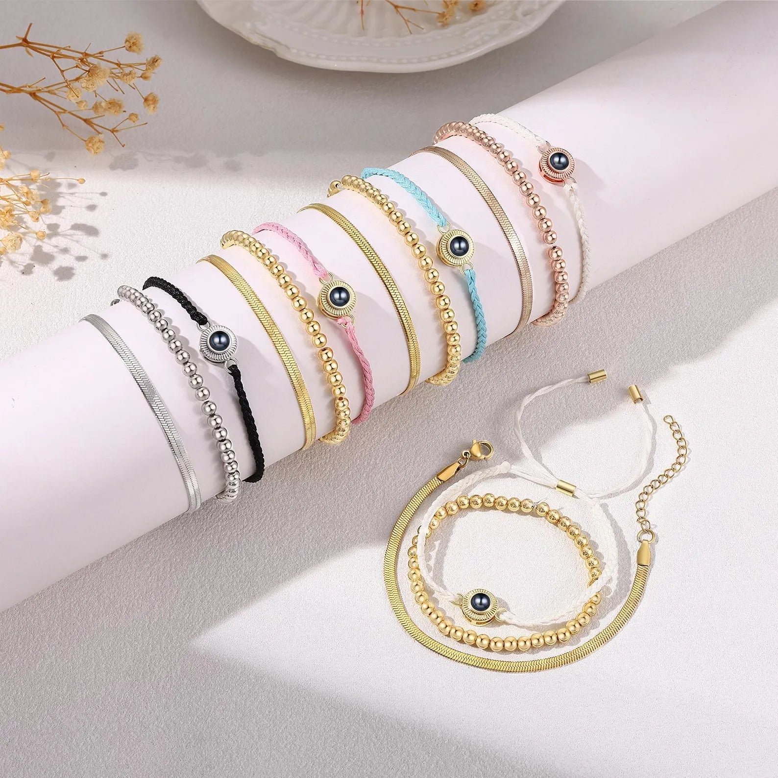 Lot de bracelets à cordon tressé en plusieurs couleurs avec perles dorées et pendentif œil en acier inoxydable.