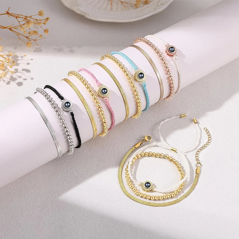 Lot de bracelets à cordon tressé en plusieurs couleurs avec perles dorées et pendentif œil en acier inoxydable.