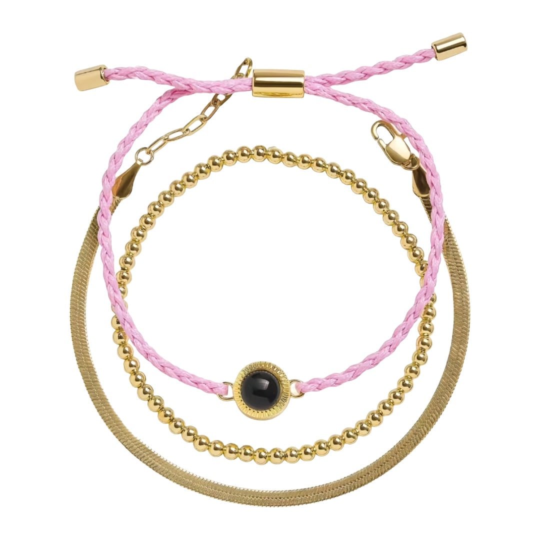 Bracelet trio perles dorées en acier avec cordon tressé rose clair et plaque lisse, fermoir réglable.