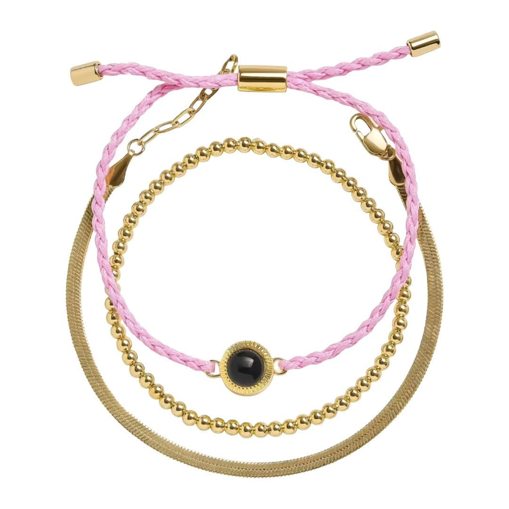 Bracelet trio perles dorées en acier avec cordon tressé rose clair et plaque lisse, fermoir réglable.