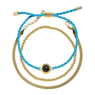 Bracelet trio cordon bleu tressé et perles dorées en acier inoxydable avec détail projection photo noir au centre.