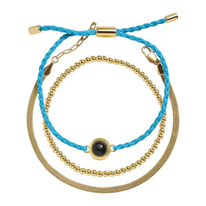 Bracelet trio cordon bleu tressé et perles dorées en acier inoxydable avec détail projection photo noir au centre.