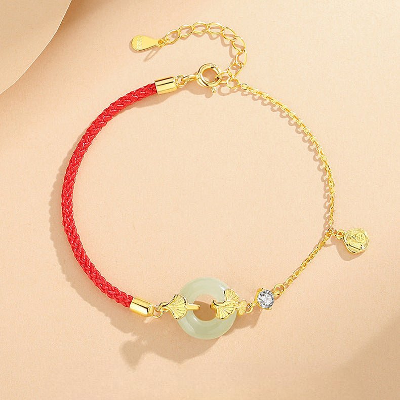 Bracelet en nylon rouge et argent 925 avec pierre de jade ronde et détail chaîne fine dorée.