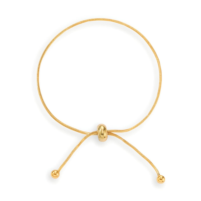 Bracelet ajustable en titane doré avec glissière centrale et extrémités boules élégantes.