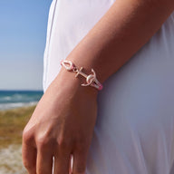 Bracelet ancre en coton rose et acier inoxydable, fermoir ancre argentée, porté au poignet féminin.