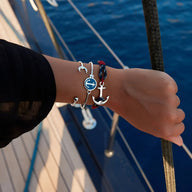 Bracelet ancre en coton bleu et acier inoxydable argenté avec détail rouge pour homme.