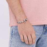 Bracelet ancre noir en cuir avec fermoir en acier inoxydable porté au poignet homme.