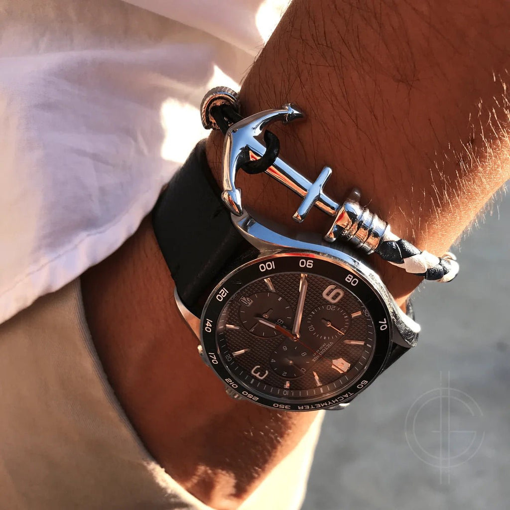 Bracelet ancre en cuir noir avec fermoir en acier inoxydable porté au poignet.