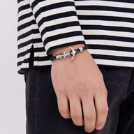 Bracelet ancre en cuir noir avec fermoir en acier inoxydable porté homme.