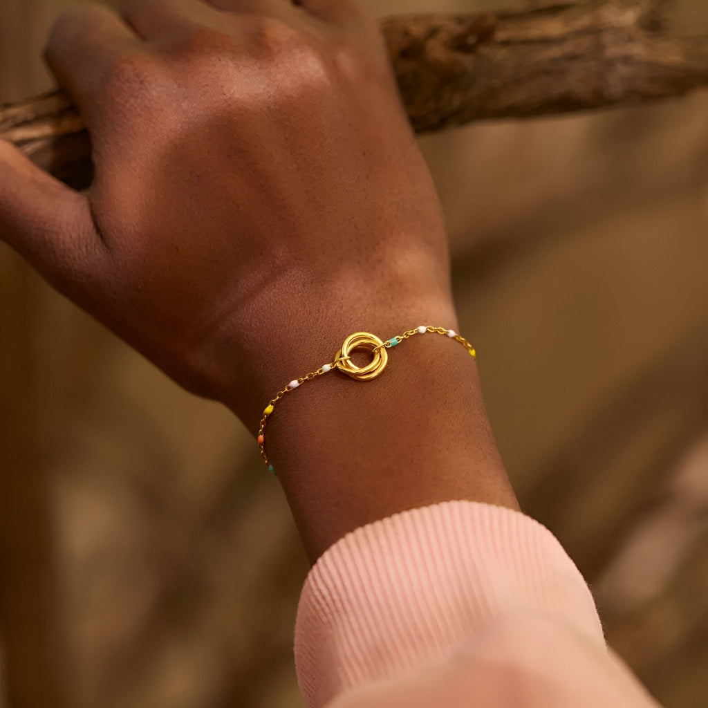 Bracelet fin en or avec anneaux entrelacés et chaîne fine pour femme.