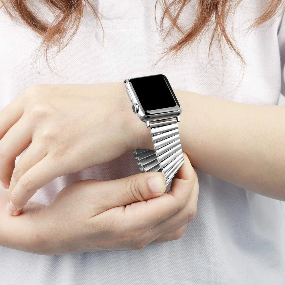 Bracelet Apple Watch en acier inoxydable argenté à maillons élastiques extensibles, design sans fermoir, porté au poignet.