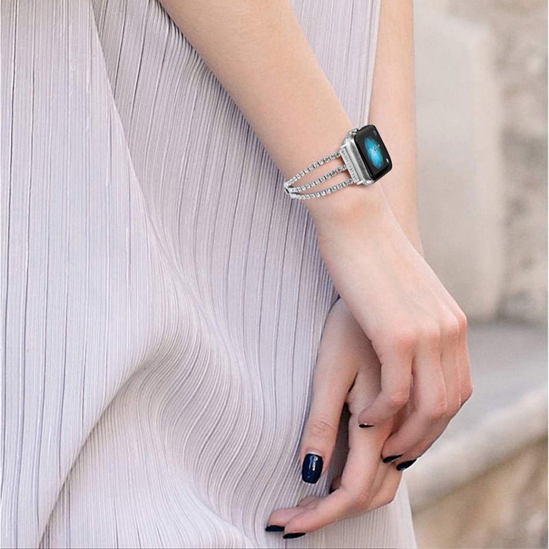 Bracelet pour Apple Watch à double rangée de cristaux scintillants argentés avec fermoir élégant porté au poignet féminin.