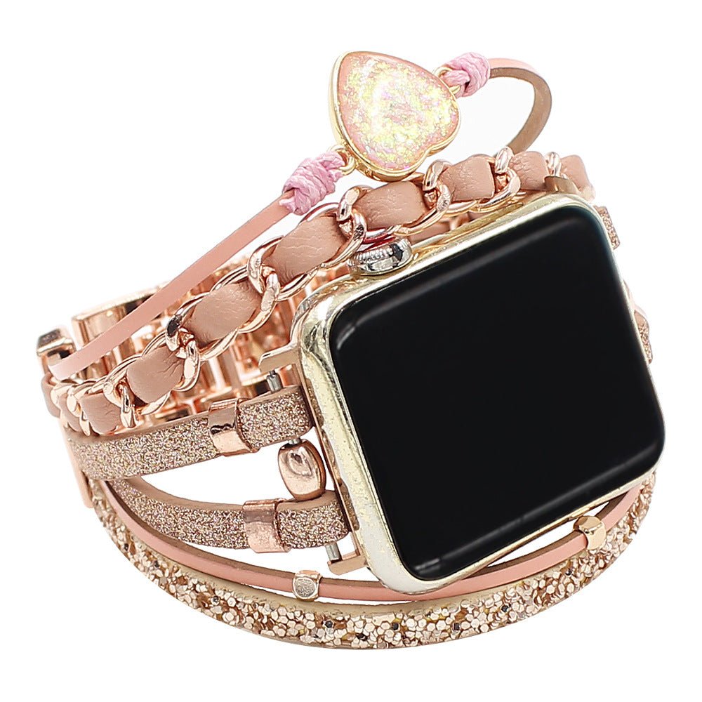Bracelet Apple Watch pour femme en cuir rose tressé avec pierre cœur pailletée et éléments dorés brillants.