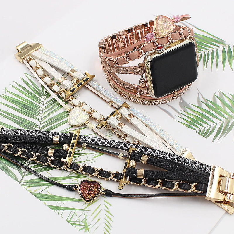 Bracelet Apple Watch femme cuir tressé noir, orné d'une pierre cœur pailletée rouge et détails dorés.